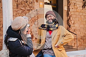 one photographer woman shooting a portrait to her posing husband with her professional camera on a journey trip. Tourist