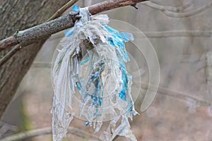 one piece of blue white dirty old cellophane hanging tied in a knot