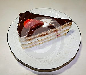 One piece of chocolate cake with strawberries on a white plate