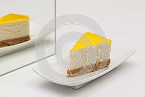 One piece of lemon cheesecake on a white plate.