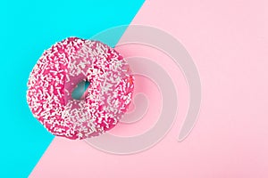 One pink isolated donut on a mint and pink background
