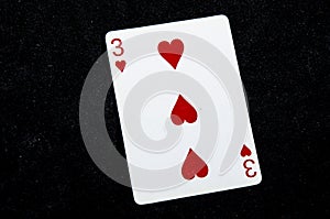 One playing card the three of harts