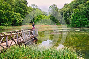 One of the ponds of the Ermitage Arlesheim, Basel-Country, Switzerland. A woman is standing on the jetty, looking to the water