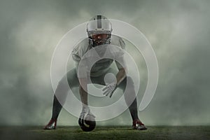 One portrait of young man, american football player at stadium in motion on smoked background. Sport, challenge, goals