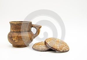 One pottery mug and a few gingerbread cookies on a white background