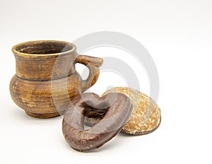 One pottery mug and a few gingerbread cookies on a white background