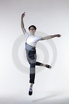 One Professional Caucasian Male Ballet Dancer Performing in Flight With Hands Outspread