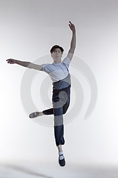 One Professional Caucasian Male Ballet Dancer Performing in Flight With Hands Outspread Performing in Flight