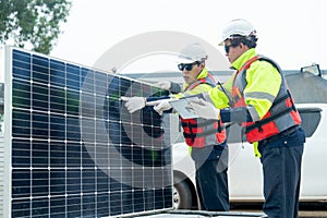 One of professional technician worker point to the problem area of solar cell panel and discuss with his co-worker in concept of