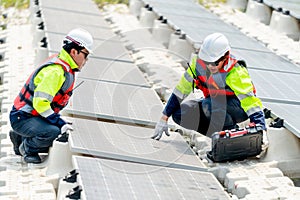 One professional technician worker sit and touch solar cell panel and discuss with co-worker for working with system over the