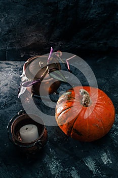 One pumpkin squash and copper or brass witch pots with candles