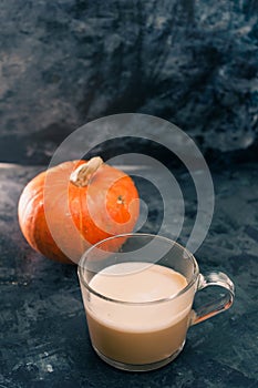 One pumpkin squash and a latte coffee made with with plant based oat soya or almond milk  with blank notepad notebook at the table