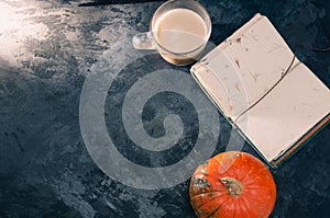 One pumpkin squash and a latte coffee made with with plant based oat soya or almond milk  with blank notepad notebook at the table