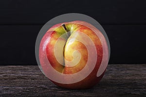 One red apple close up and copy space on the background of a rusty table. An ugly apple with rot