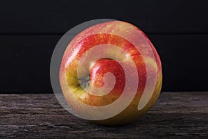 One red apple close up and copy space on the background of a rusty table. An ugly apple with rot