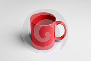 One red ceramic mug on light background