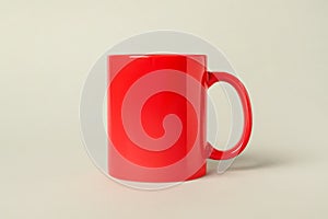 One red ceramic mug on light grey background