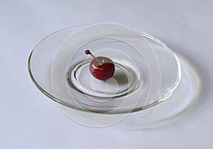One red cherry in the center of the plate
