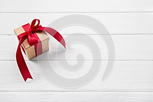One red christmas present on white wooden background with a big