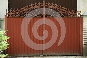 One red closed iron gate with a wrought iron pattern