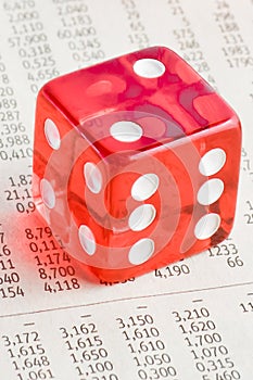 One red dice on the financial newspaper