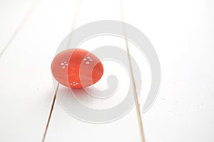 One red Easter egg on white wooden background