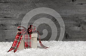 One red green checkered christmas present with ribbon on wooden