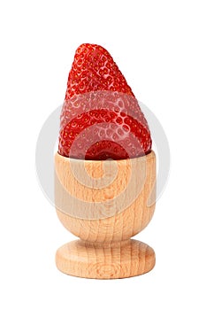 One red mellow strawberry in eggcup over white