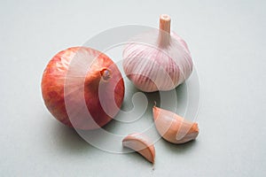 One red onion and one garlic on a green background. Folk remedies for raising immunity.