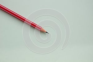 One red pencil on a light green background.