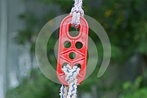 one red plastic carabiner clasp hanging from a white rope