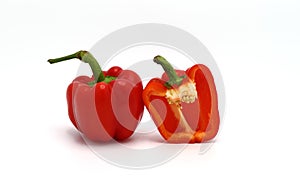 One red ripe sweet pepper and one half pepper on a light background.