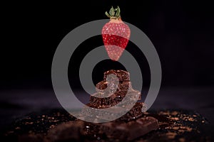 One red straberry on a dark chocolate