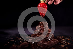 One red straberry on a dark chocolate