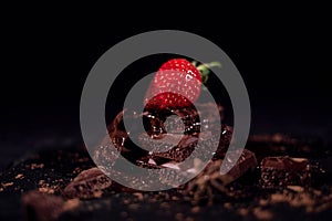 One red straberry on a dark chocolate