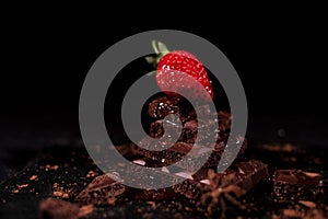 One red straberry on a dark chocolate