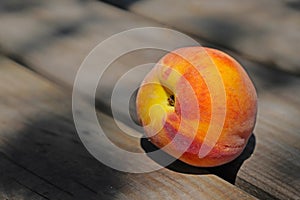 One ripe peach on wooden table