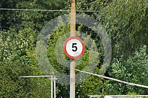 One road sign speed limit five kilometers hanging on a gray concrete pole in the street