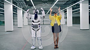 One robot copies woman`s movements, while she wears VR glasses.