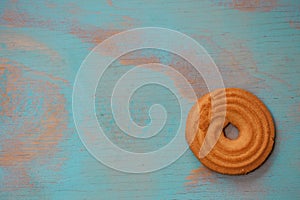One round butter cookies/biscuits on wooden teal green rustic background with space for text, flat lay design with butter cookie photo