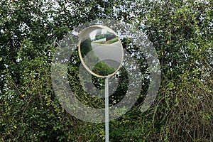 One round mirror on a gray pillar by the road