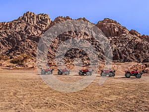 One row of ATVs in the Sinai desert against the backdrop of mountains, no people