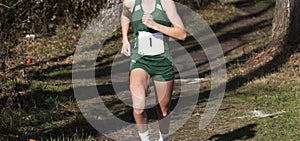 One runner exiting the woods suring a high school cross country race