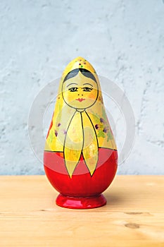 One russian doll on wooden table