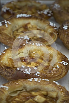 One serving baked apple pies in a row at the market