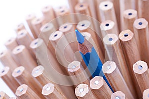 One sharpened blue pencil among many ones