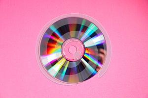 One shiny compact disc on pink background, top view
