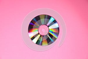 One shiny compact disc on pink background, top view