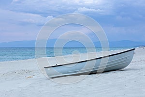 One ship on the beach under clouds .