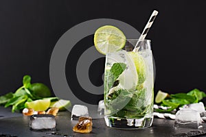 One shot of mojito cocktail in glass on black table. Low key photo. Close up.